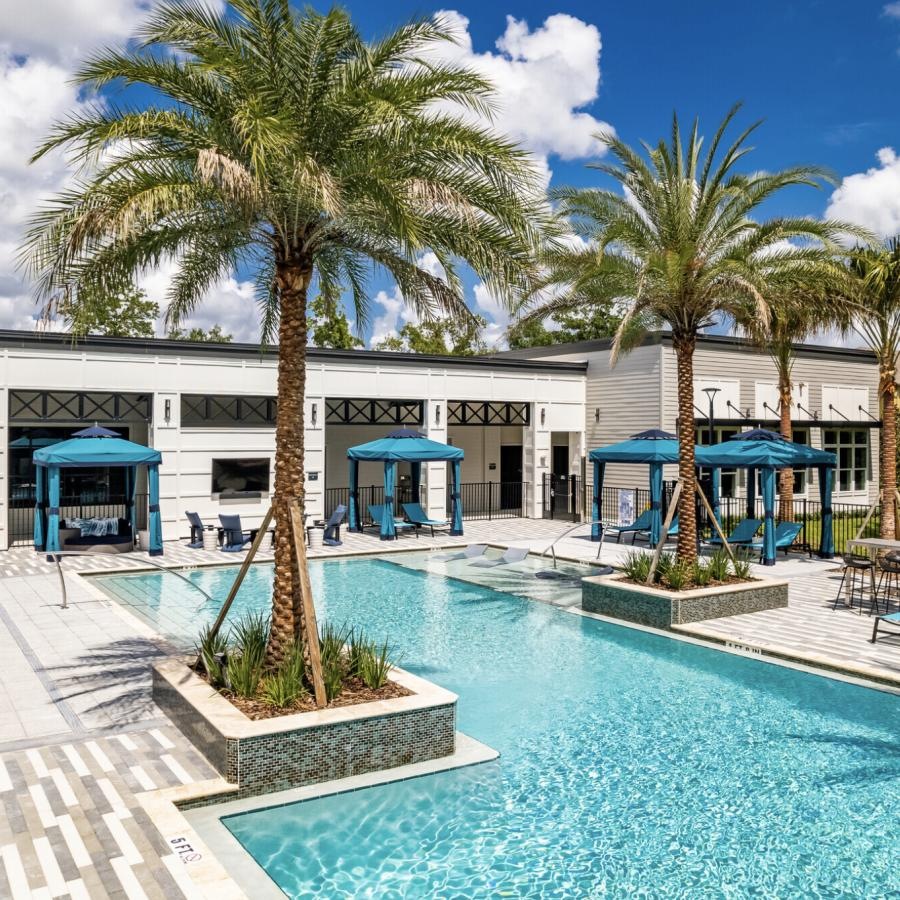 a pool with palm trees and a building in the background